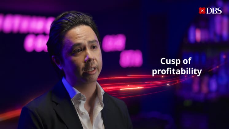 A person in a suit with neon text, "Cusp of profitability."